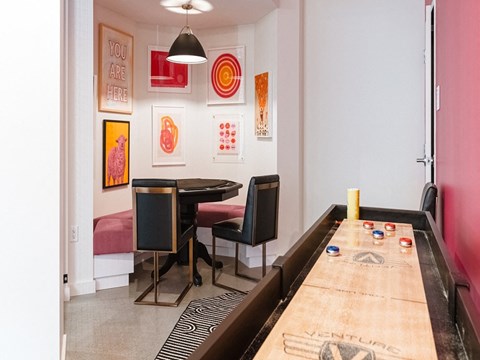 a dining room with a long table and chairs and a wall of art